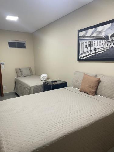 皮雷诺波利斯Hotel Santa Maria的一间卧室设有两张床,墙上挂着一幅画
