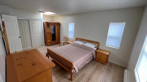 BowserPenthouse的一间卧室配有一张床、一张桌子和两个窗户
