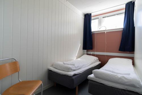 雷讷Reine Basecamp - Apartments & Rooms的小房间设有两张床和窗户