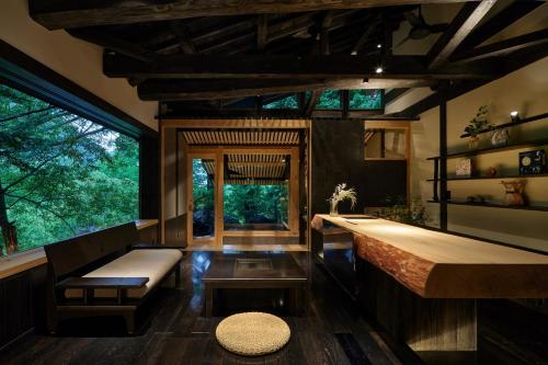 高山飞騨路传统日式旅馆（仅限成人入住）的客房设有长凳、桌子和一些窗户。