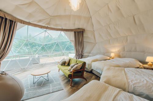 LUONTE 霧の高原 Glamping的客房设有两张床和大窗户。