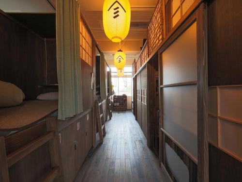 MurayamaYamagata Guesthouse山形ゲストハウス的空的走廊,有两张床和灯具