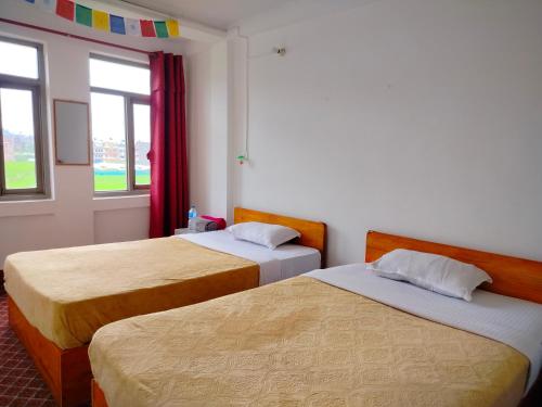 PanaotiCOMMUNITY HOLIDAY INN的客房设有两张床和窗户。