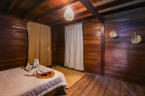 吉利特拉旺安格林拉浪旅馆的卧室配有一张床铺,位于带木墙的房间内