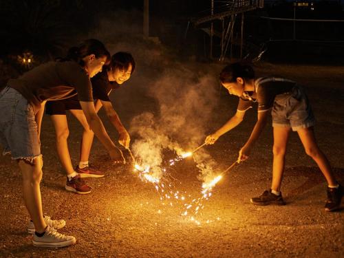 宜野座斯纳敦度假屋的街上有四个女孩和火花玩