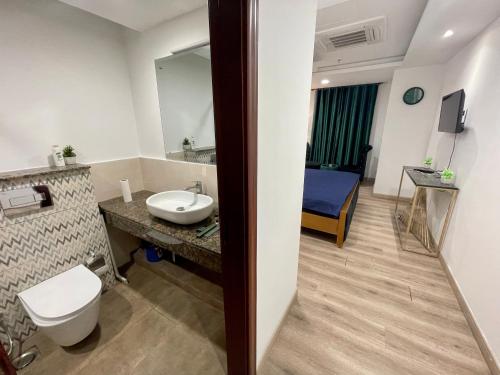 拉合尔AirReside Hotel Apartments Gold Crest的一间带水槽和卫生间的浴室以及一张床