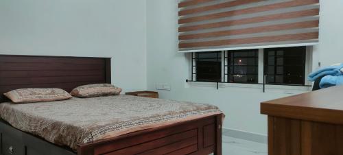特里凡得琅Luxurious Apartment with a pool and gym near Trivandrum railway station的一间卧室配有床和两个枕头