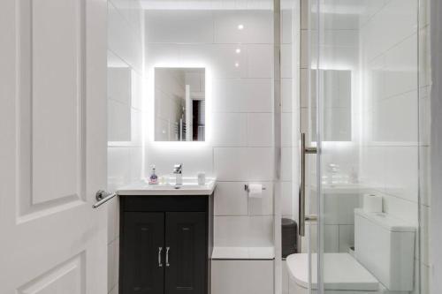 曼彻斯特GuestReady - Northern Quarter Urban Escape的一间带水槽、卫生间和镜子的浴室