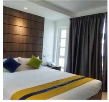 波德申Solesor Kampong Beach Resort的一间卧室配有一张带蓝色和绿色枕头的大床