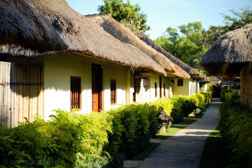 金巴兰Jimbaran Puri, A Belmond Hotel, Bali的一排茅草屋顶的房屋