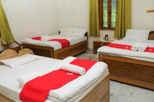 乌德尔格希Geetanjali Resort的一间设有两张红色和白色床单的房间