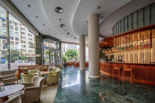 瓦伦西亚瓦伦西亚广场美利亚酒店的一间带桌椅的餐厅和一间酒吧