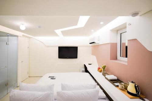 首尔SimpleStay Hotel in Jongno的一间卧室设有一张床,天花板上配有电视。