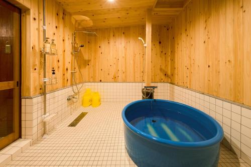 Tadotsu一棟貸切宿 空と家 本棟的木质墙壁浴室内的蓝色大浴缸