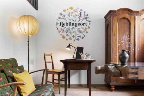上陶恩Sloho Bergurlaub的客厅配有书桌和带台灯的桌子