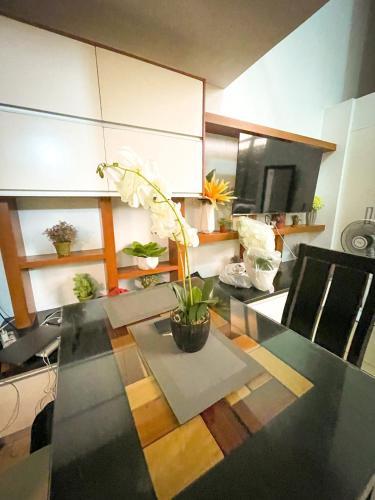 马尼拉Lovely 1BR Loft in BGC up to 6pax的一间用餐室,配有一张桌子和植物