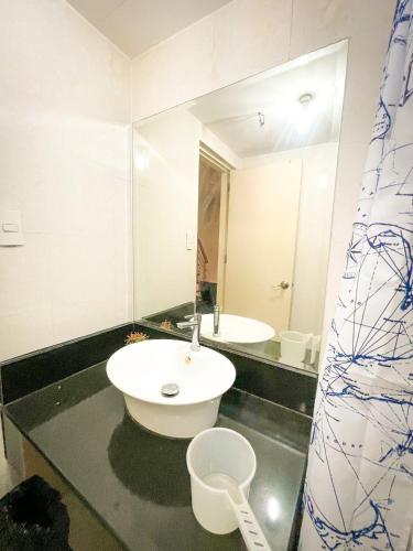 马尼拉Lovely 1BR Loft in BGC up to 6pax的一间带水槽和镜子的浴室