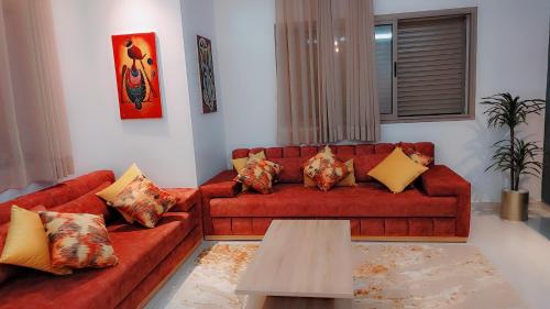 布兹尼盖Appartement Nova - Costa Bouznika的客厅配有红色的沙发和桌子