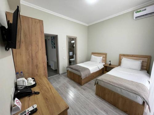 塔什干Airport Hotel 24的酒店客房设有两张床和一台平面电视。