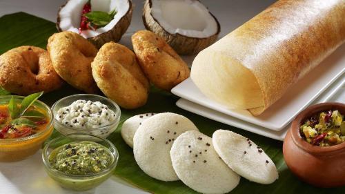 贝格尔ShriGo Bekal Fort Resort & Spa的餐桌上摆放着面包和各种食物