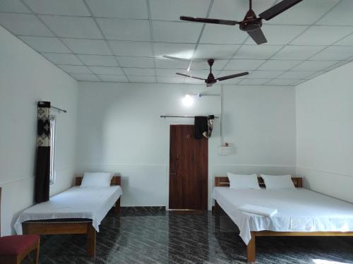 Jyoti GaonFalcon Jungle Resort的客房设有两张床和吊扇。