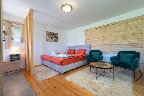 扎布利亚克Apartments CENTER OF THE WORLD的一间卧室配有一张床、两把椅子和一张桌子