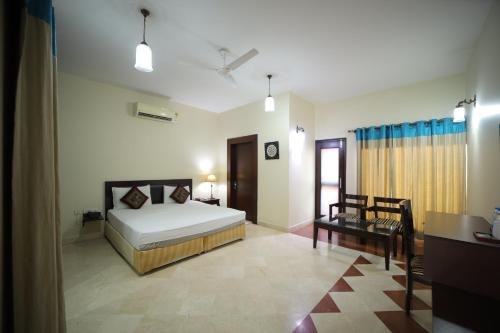 阿格拉Bansi Home Stay的一间卧室,卧室内配有一张床和一把椅子