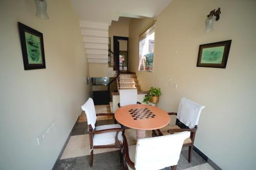 阿格拉Bansi Home Stay的一间带桌子和白色椅子的用餐室