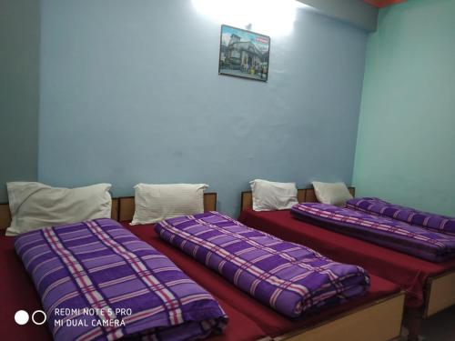 KedārnāthKedarnath Jk prithvi yatra的紫色床单的客房内的两张床