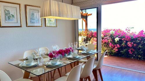 丰沙尔Casa ideal para famílias com vista mar desafogada的一间带桌椅和鲜花的用餐室
