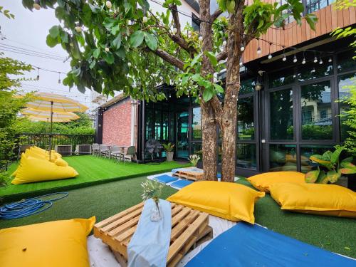 曼谷廊曼机场维哈旅舍的天井设有黄色枕头和树