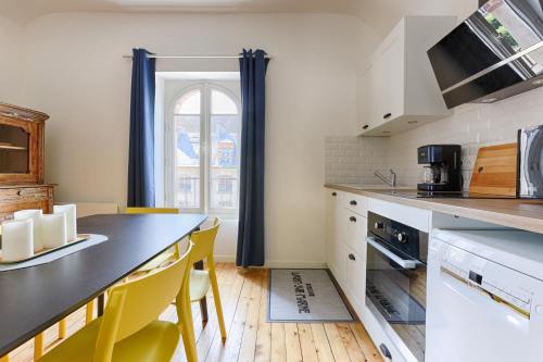 拉尼Appartements de l'Abbaye - A 10 minutes de Disneyland的厨房配有黑色柜台和黄色椅子