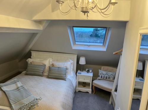 塞米斯湾Castellor Bed & Breakfast的一间卧室配有一张带吊灯和窗户的床。
