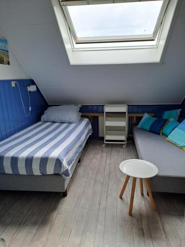 佐特兰德Unia's Verhuur的一间卧室配有一张床、一张沙发和天窗。