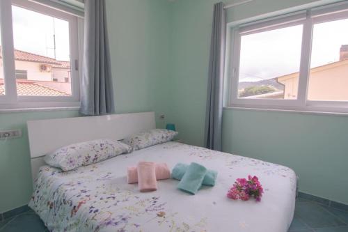 费拉约港Appartamento Sogno Marino的一间卧室配有带2条毛巾和鲜花的床
