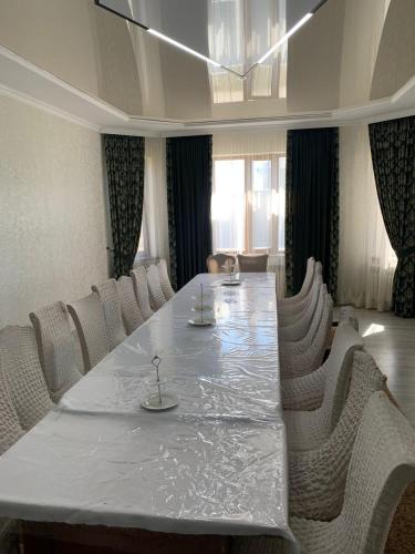 塔拉兹Гостевой Домик Жайлау的一间会议室,配有一张白色的大桌子和椅子