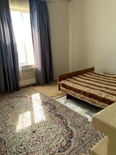 塔拉兹Гостевой Домик Жайлау的卧室配有一张床,地板上铺有地毯
