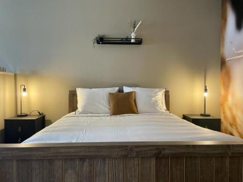 赫鲁斯贝克Camping Lagewald Vakantiehuis的一间卧室配有一张大床和两盏灯