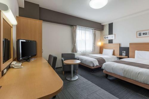 郡山郡山康福特酒店的酒店客房设有两张床、一张书桌和电视