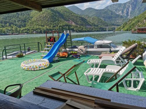 维舍格勒Splav Drina-Višegrad的湖上一群椅子和一个游乐场