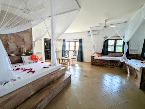 吉汶瓦巴哈蒂酒店的卧室配有2张带白色窗帘的床