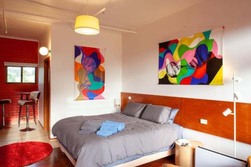 SilvanVista Suite Treetops Silvan Valley Lodge的卧室配有一张床,墙上挂有两幅画
