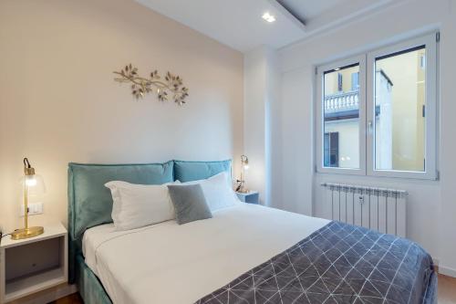 米兰Milan Retreats的卧室配有白色的床和窗户。