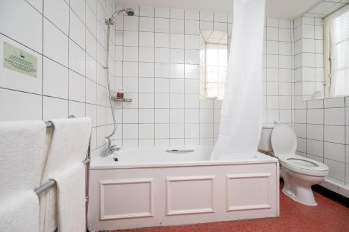 阳光港Bridge Inn by Greene King Inns的白色的浴室设有浴缸和卫生间。