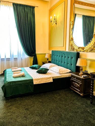 布加勒斯特Hotel Boutique Casa Vermont的一间卧室配有一张带蓝色床头板和镜子的床