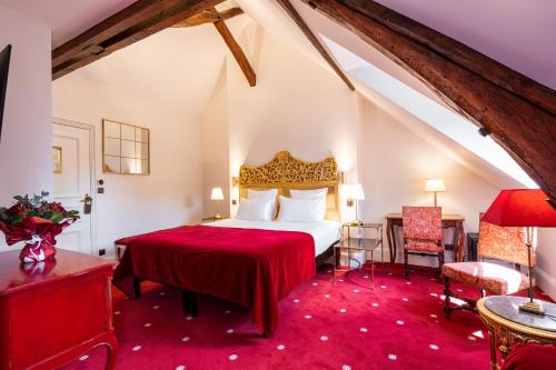 阿姆博斯马诺尔圣托马斯酒店的一间卧室配有一张红色床罩的床