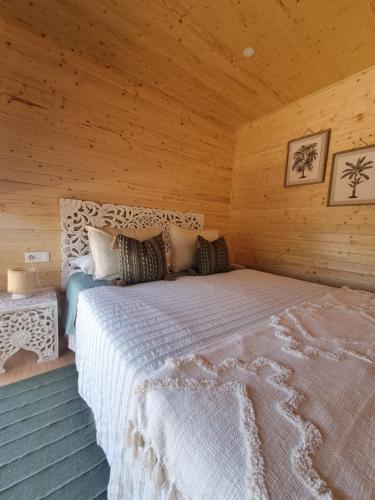 阿尔戈什Eco Lodge Villa das Alfarrobas com Piscina的小木屋内一间卧室,配有一张大床