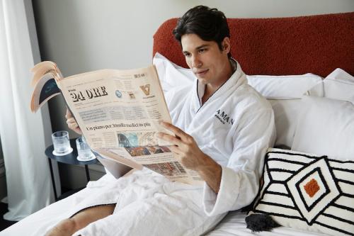 罗马HOTEL VITE - By Naman Hotellerie的坐在床上看报纸的人