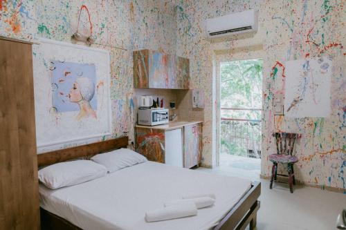 海法Hotel Loui Talpiot的壁纸客房内的一间卧室配有一张床