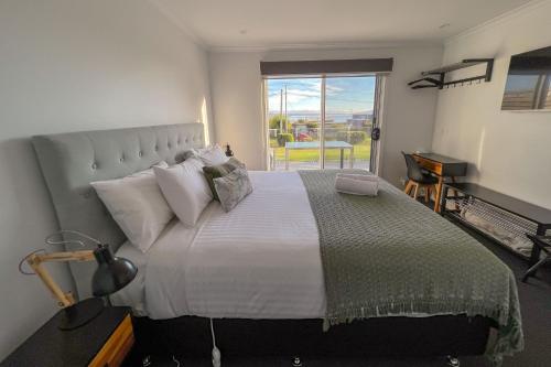 比那隆湾BINALONG BRAE @ Bay of Fires Two bedroom both with ensuites的一间卧室设有一张大床和大窗户